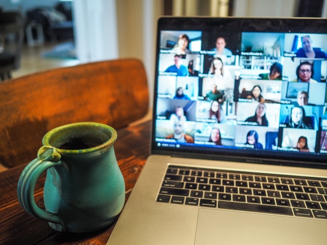 A cup of coffee next to a laptop during a remote meeting